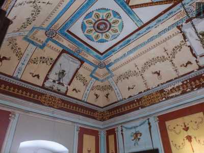 Attraverso un�altra porta giungiamo in un grazioso salottino con decori in stile pompeiano